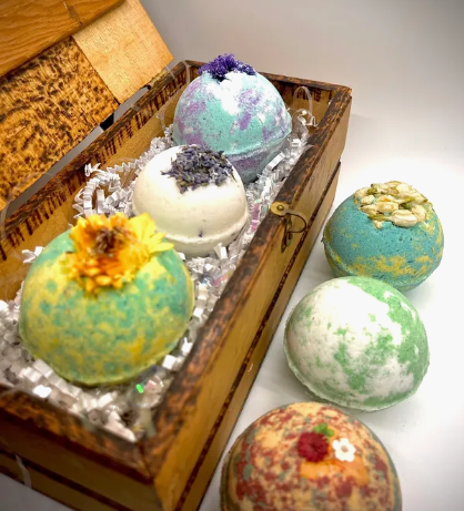 A wooden box filled with bath bombs next to other bath bomb.