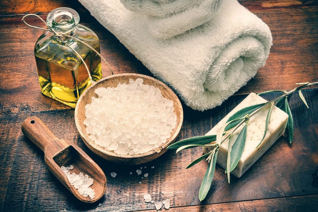 A wooden table topped with a bowl of rice next to some soap.