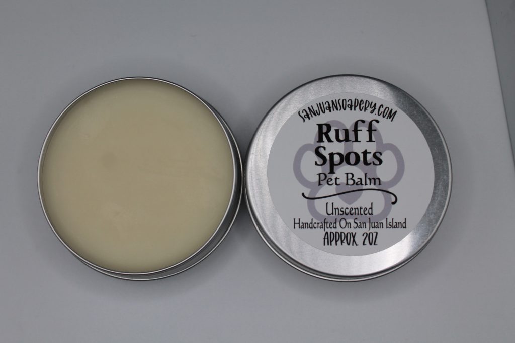 A tin of dog paw balm with the lid open.