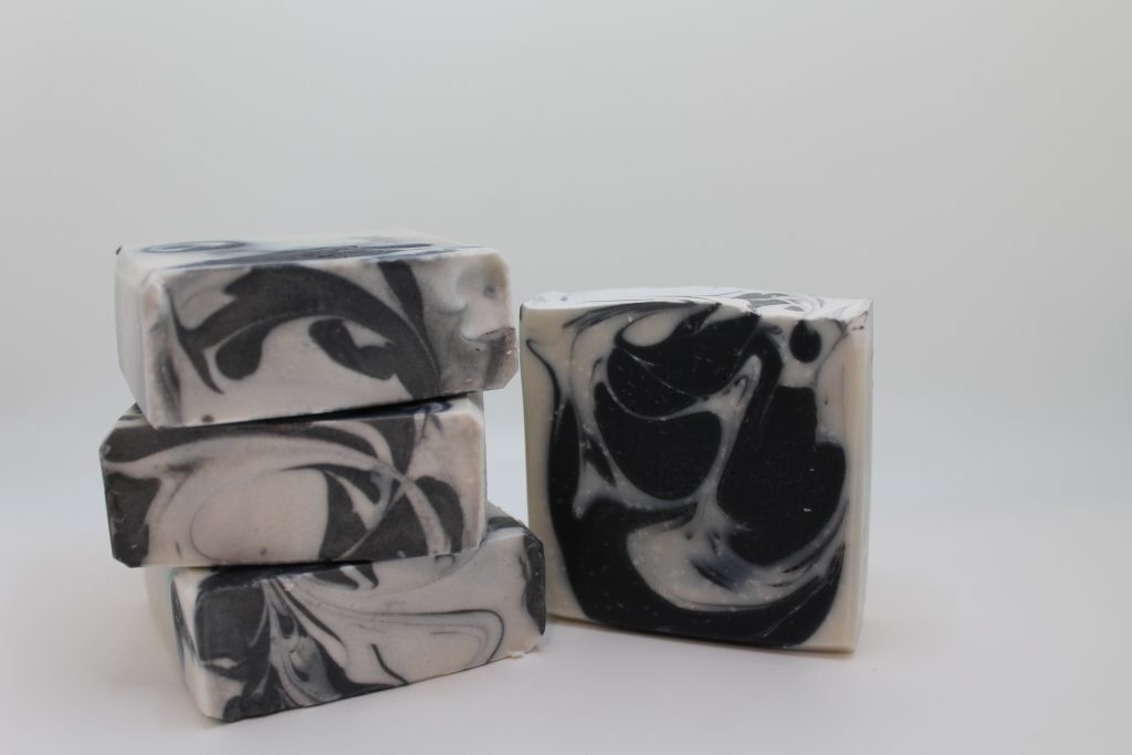 A stack of four soap bars with black and white swirls.