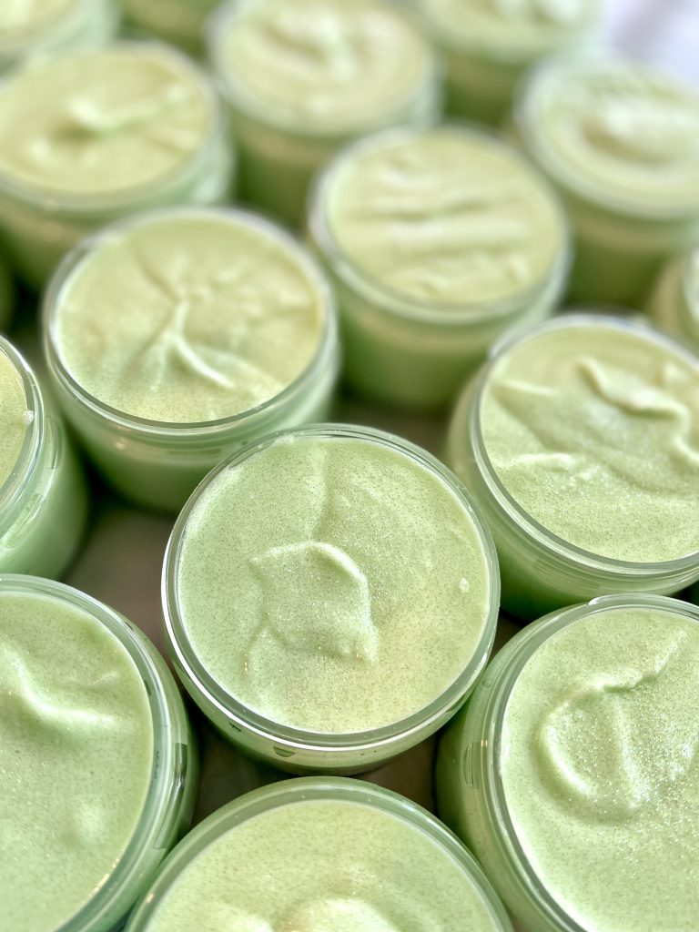 A close up of many jars with green colored creams