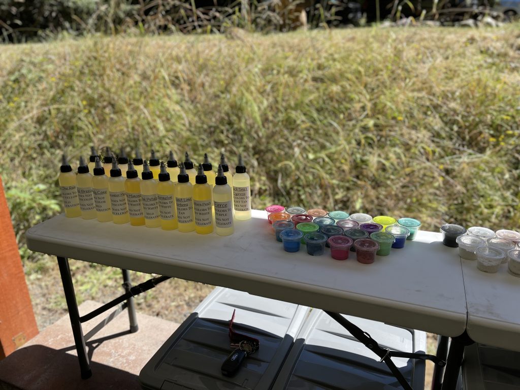 A table with several bottles of alcohol and cups on it.