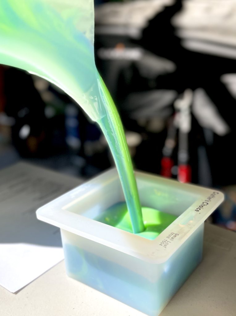 A green liquid is being poured into a container.