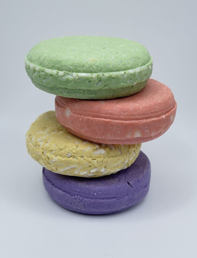 A stack of four different colored macarons.