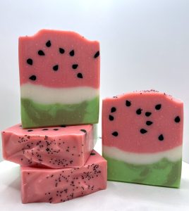 A stack of watermelon soap with black and white seeds.