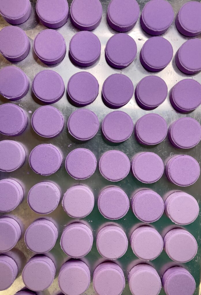 A bunch of purple plastic lids sitting on top of a table.